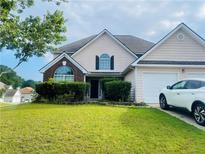 Charming two-story home with manicured lawn and attached garage, perfect for suburban living at 15 Emerson Trl, Covington, GA 30016