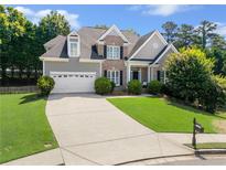 Charming two-story home featuring a manicured lawn and brick and gray siding at 1539 School House Run, Dacula, GA 30019