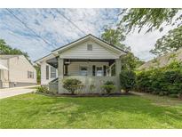 Charming bungalow featuring a covered porch, landscaped front yard, and classic architectural details at 523 North Ave, Atlanta, GA 30354