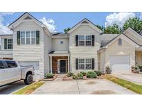 Charming two-story townhome featuring a black front door, attached garage, and low-maintenance landscaping at 1362 Rogers Trce, Lithonia, GA 30058