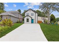 Charming two-story home featuring a bright blue front door and a long driveway at 1164 Red Oak Cv, Tucker, GA 30084