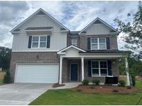 Two-story brick home with a white garage door, black shutters, and a well-manicured lawn at 1857 Kingsmere Run Dr, Loganville, GA 30052