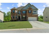 Charming two-story brick home featuring a well-manicured lawn and two-car garage at 5345 Mirror Lake Dr, Cumming, GA 30028
