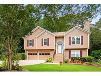 Charming two-story home with a well-manicured lawn, attached garage, and inviting entrance at 3049 Heathgate Ct, Lawrenceville, GA 30044