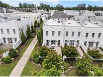 Stunning aerial view of a white brick townhouse community with beautifully landscaped yards and inviting outdoor patios at 323 S Esplanade, Alpharetta, GA 30009