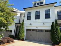 Charming townhome showcasing a well-maintained front yard and a convenient two-car garage at 341 Bailey Walk, Alpharetta, GA 30009