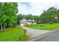 Charming two-story home with a well-manicured lawn and a long driveway leading to the garage at 1137 Eagles Nest Cir, Carrollton, GA 30116