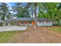 Charming home with a lovely yard and a bright orange front door at 2271 Columbia Dr, Decatur, GA 30032