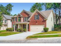 Charming two-story brick home with manicured lawn and a two-car garage at 3677 Trillium Forest Dr, Snellville, GA 30039