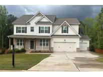 Charming two-story home with a large driveway, three-car garage, and beautifully maintained lawn at 8225 Crooked Creek Dr, Cumming, GA 30028