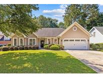 Charming single-story home with a well-manicured lawn, a two-car garage, and lush landscaping at 3072 Oaktree Ln, Duluth, GA 30096