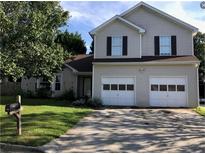 Charming two-story home with an attached two car garage and well-maintained lawn at 857 Asbury Trl, Lithonia, GA 30058