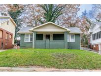Charming craftsman-style house with painted brick facade and welcoming front porch on a well-manicured lawn at 1174 Donnelly Sw Ave, Atlanta, GA 30310