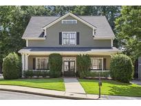 Charming two-story home with landscaped front yard and classic architectural details and green siding at 2213 Parkview Nw Ct, Atlanta, GA 30318