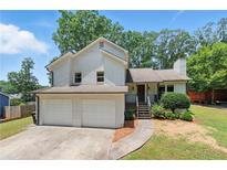 Charming home featuring a two-car garage, lush landscaping, and inviting front entrance at 4829 Caboose Nw Ln, Acworth, GA 30102