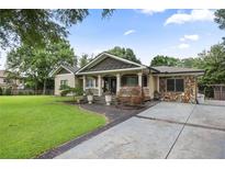 Beautiful ranch-style home showcasing a well-manicured lawn and inviting stone accents for added curb appeal at 1665 Cunningham Road Southwest Sw Rd, Marietta, GA 30008