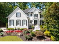 Charming, bright two-story home with black shutters and beautiful landscaped front yard at 2184 Summerchase Dr, Woodstock, GA 30189