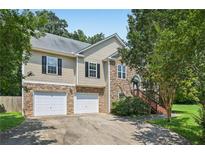 Charming two-story home boasts a stone facade, two-car garage, and inviting entrance with wooden steps at 346 Majestic Run, Temple, GA 30179