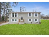 Charming two-story home with a brick facade, manicured lawn, and white shutters at 216 Scarsdale Dr, Riverdale, GA 30274