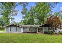 Charming single-story home with a well-manicured lawn and mature trees at 4370 Mabry Ln, Roswell, GA 30075