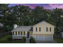 Charming home with a two-car garage, front porch, lush green lawn and mature trees at 604 Meadows Ct, Villa Rica, GA 30180