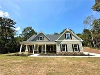 Charming home featuring a welcoming front porch, black shutters and a well-manicured lawn at 22 Stratford Way, Kingston, GA 30145