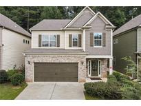 Charming two-story home with brick accents, a two-car garage, and manicured landscaping at 124 Freedom Dr, Acworth, GA 30102