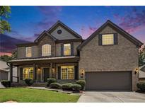 Beautiful two-story brick home with a well-manicured lawn and inviting front porch at dusk at 1883 Jameson Cir, Lawrenceville, GA 30043