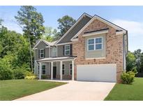 Beautiful two-story home featuring a brick and gray siding exterior and a two car garage at 1800 Pearson St, Loganville, GA 30052