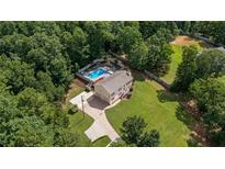 Aerial view of two story home with a large pool, long drive, and mature trees at 450 Ledbetter Rd, Villa Rica, GA 30180