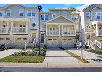 Charming townhome with a porch, balcony, driveway, and attached garage at 1081 Liberty Nw Pkwy, Atlanta, GA 30318