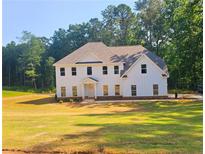 Striking white two-story modern farmhouse with a symmetrical facade and verdant lawn at 790 Turner Rd, Mcdonough, GA 30252