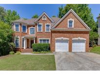 Charming two-story brick home with well-manicured lawn, two-car garage, and mature trees at 4085 Creekview Ridge Dr, Buford, GA 30518