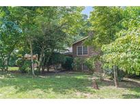 View of a two-story home featuring a brick chimney and surrounded by lush trees at 1737 Fontaine Dr, Jonesboro, GA 30236