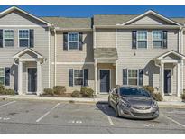 Well-maintained townhome featuring neutral siding, black shutters, and assigned parking at 4043 Avalon Sw Rd, Atlanta, GA 30331