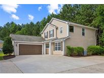 Charming two-story home with a two car garage, manicured lawn and lush landscaping at 7567 Waverly Loop, Fairburn, GA 30213