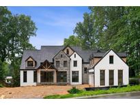 Striking new construction home boasts a modern farmhouse design with stone and painted brick accents at 3661 Clubwood Trl, Marietta, GA 30068