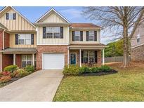 Charming two-story townhouse with a brick facade, well-maintained lawn, and an attached one-car garage at 4037 Hill Station Ct, Sugar Hill, GA 30518