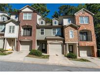 Charming townhome with brick and stone accents, featuring a one-car garage and well-maintained landscaping at 2986 Ashlyn Pointe Dr, Atlanta, GA 30340