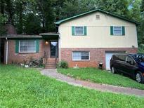 Charming split-level home featuring a brick facade and a well-maintained front yard with mature trees at 2275 Chestnut Log Loop, Lithia Springs, GA 30122