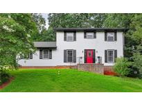 Charming two-story home featuring a bright red front door, black shutters and a lush green lawn at 4756 Manly Ct, Stone Mountain, GA 30088