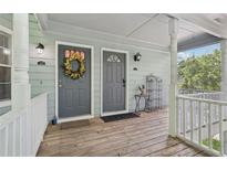 Inviting covered front porch featuring two entry doors, natural light, and classic design elements at 3961 Riverlook Se Pkwy # 209, Marietta, GA 30067