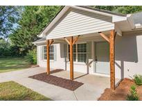 Charming home front porch with wooden supports, white siding, and updated landscaping at 1834 Stroud Road, Mcdonough, GA 30252