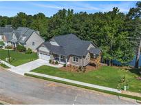 Beautifully landscaped house with an attached two-car garage and a cozy side porch overlooking the lake at 301 Retreat Way, Carrollton, GA 30116