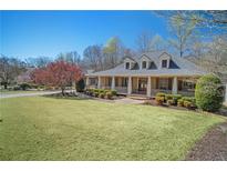 Inviting two-story home with a charming front porch and professionally landscaped front yard at 216 Crescent Moon Way, Canton, GA 30114