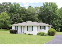 Charming single-story home with a well-maintained lawn and classic white facade, complemented by lush green landscaping at 9916 Stockmar Rd, Villa Rica, GA 30180