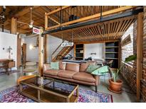 Spacious living room featuring exposed brick, high ceilings, hardwood floors, and a comfortable leather sofa at 170 Boulevard Se # H-221, Atlanta, GA 30312