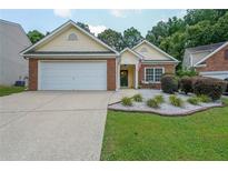 Charming single-story home featuring a well-manicured lawn and an attached two-car garage at 209 Diamond Valley Pass, Canton, GA 30114