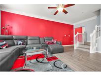 Comfortable living room with gray leather sofa, accent rug, and modern glass coffee table, plus stylish red accent wall at 10 Perimeter Summit Ne Br # 2312, Atlanta, GA 30319