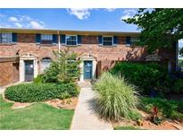 Charming brick townhome with lush landscaping and inviting blue door at 3541 Old Chamblee Tucker Rd # B, Atlanta, GA 30340